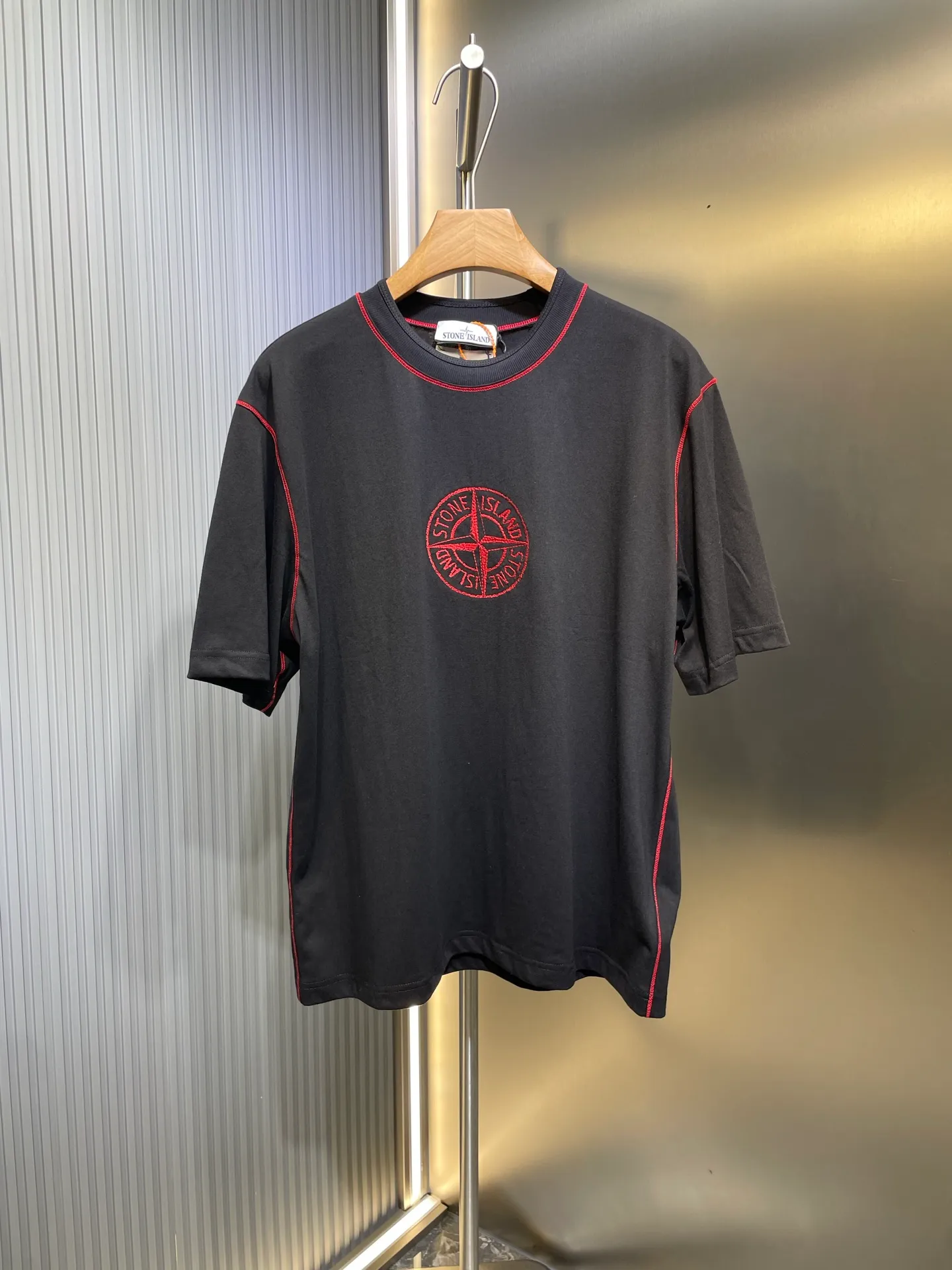 🅿️280 Stonelsland badge embroidered short sleeves. Customized elegant black silk cotton and linen plain fabric. Delicate and smooth, comfortable and skin-friendly. The iconic red Compass badge embroidery on the chest highlights the brand's imprint. Stitch art. The beauty of contrasting colors. The red stitches jump on the black base. The collision of fashion and creativity exudes irresistible charm. Process 1: Using imported machine embroidery technology, using advanced computer control systems and precision mechanical components to realize the red Compass badge embroidery operation. High precision, smooth and delicate lines. Process 2: Special machine for back-bottomed topstitch fine sewing. Special machine is used for topstitch sewing. The reverse side of the clothing is required to be carefully prepared before sewing. Ensure straight sewing lines, even stitches, smooth edges and beautiful appearance. Process 3: The fabrics are washed and have a better hand feel. Not easy to deform, not easy to shrink, not easy to fade, and maintain long-term beauty. Accessories: Customized 1:1 Stonelsland trademark. Version: Loose fit Size: S M L XL Style number: 25142-A20
